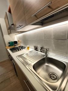 a kitchen with a stainless steel sink and a stove at Cozy Apartment in Monza City Center in Monza