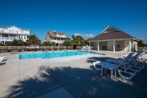 uma piscina com duas cadeiras e uma casa em Retreat 6A em Edisto Island