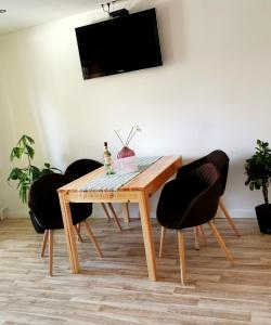 a wooden table with chairs and a television on a wall at Ferienwohnung mit Schlossblick in Wernigerode