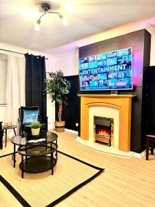 a living room with a fireplace with a television above it at Rooms Near Me - Worcester, Sky Tv, Free Double Parking in Worcester