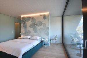 1 dormitorio con cama y pared con mariposas en The Window, en Bellinzona