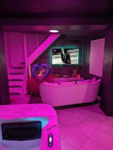 a pink room with a bath tub and a bed at Le Spacidulé in Saint-Amand-les-Eaux