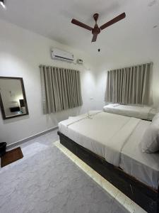 a bedroom with a bed and a ceiling fan at La Tamara Auroville in Auroville