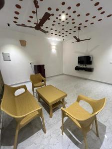 a room with chairs and a table and a ceiling at La Tamara Auroville in Auroville