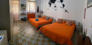 Sunrise Apartment في فاليتا: سريرين في غرفة مع أغطية برتقالية
