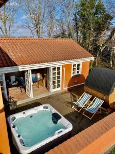 a small house with a hot tub on a deck at Fantastic Spa-house Surrounded By Nature in Udsholt Sand