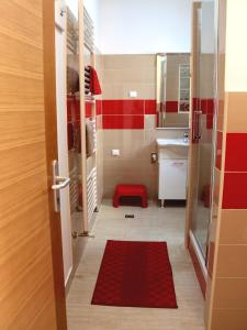 baño pequeño con pared roja y blanca en Apartmani Nighty Night, en Zagreb