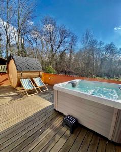 bañera de hidromasaje en una terraza con 2 sillas en Fantastic Spa-house Surrounded By Nature en Udsholt Sand