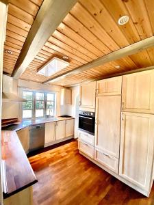 a large kitchen with wooden floors and a wooden ceiling at Fantastic Spa-house Surrounded By Nature in Udsholt Sand