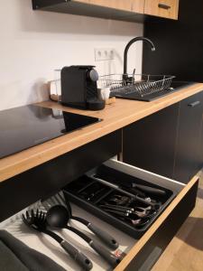Indigo Apartment Urusagului في فلورستي: مطبخ مع درج مفتوح مع ادوات الطبخ