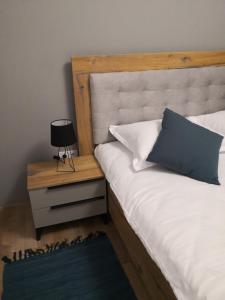 Indigo Apartment Urusagului في فلورستي: غرفة نوم مع سرير مع وسادة زرقاء و كومودينو