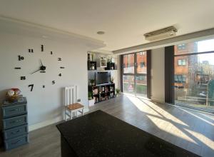 una sala de estar con un reloj grande en la pared en Luxurious En-Suite in the heart of stratford, en Londres