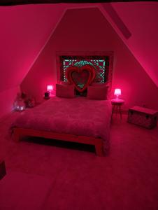 Un dormitorio con una cama con una pintura al corazón. en Le Spacidulé, en Saint-Amand-les-Eaux
