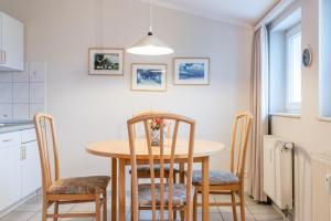 eine Küche und ein Esszimmer mit einem Tisch und Stühlen in der Unterkunft Fewo 388, Seepark Sellin in Ostseebad Sellin