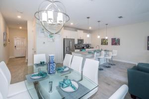 una sala da pranzo e una cucina con tavolo e sedie in vetro di 4933IG TOWNHOUSE 4 BED/3 BATHS (SANITIZED) a Kissimmee