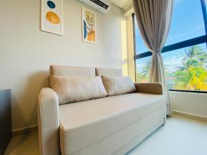 a white couch in a room with a window at Ocean Porto Flats in Porto De Galinhas