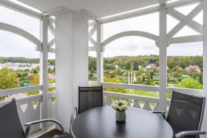 a table on a balcony with a view of the city at Fewo 405, Seepark Sellin in Ostseebad Sellin