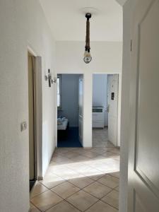 a hallway with white walls and a tile floor at Große Terrassenwohnung mit Seeblick in Stechlin