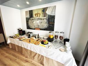 una mesa buffet con comida en una habitación en Antídoto Rooms Zocodover, en Toledo