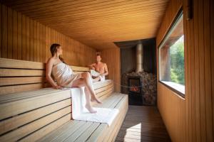 a woman sitting on the edge of a sauna at Thermae Grimbergen Hotel in Grimbergen