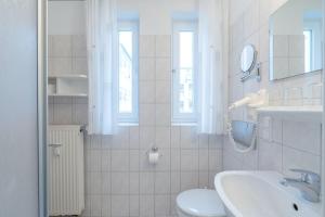 uma casa de banho branca com um lavatório e um WC em Fewo 601, Seepark Sellin em Ostseebad Sellin