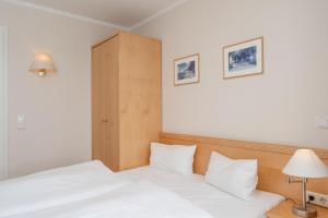 een slaapkamer met een wit bed met 2 kussens bij Fewo 619, Seepark Sellin in Ostseebad Sellin