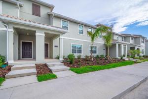 una casa con palmeras delante en 4819JA TOWNHOUSE 4 BEDROOMS & 3 BATHROOMS + POOL, en Kissimmee