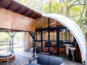 a house with an arched roof and a living room at Nagano GLAMPINGBASE enCamp in Shiojiri