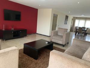 a living room with a couch and chairs and a table at The Emem Apartment Collections in Lagos