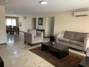 a living room with two couches and a coffee table at The Emem Apartment Collections in Lagos