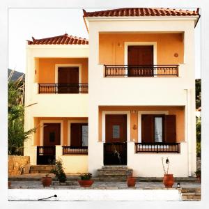 a house with balconies on the side of it at Anemos Apartments in Marathokampos