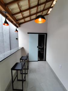 Zimmer mit 2 Stühlen, einem Tisch und einer Tür in der Unterkunft Loft 61 - No coração de Curvelo in Curvelo