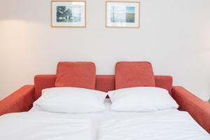 Bett mit rotem Kopfteil und zwei weißen Kissen in der Unterkunft Fewo 641, Seepark Sellin in Ostseebad Sellin