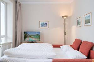 ein Schlafzimmer mit einem weißen Bett und einem Sofa in der Unterkunft Fewo 641, Seepark Sellin in Ostseebad Sellin