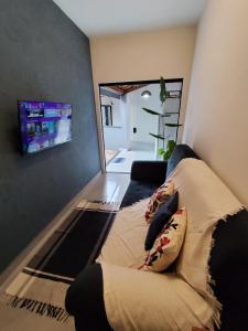 a living room with a couch and a flat screen tv at Loft 61 - No coração de Curvelo in Curvelo