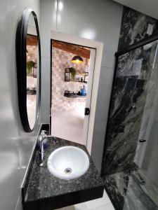 a bathroom with a sink and a mirror at Loft 61 - No coração de Curvelo in Curvelo