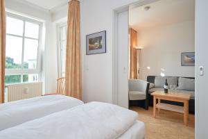ein Hotelzimmer mit einem Bett und einem Wohnzimmer in der Unterkunft Fewo 647, Seepark Sellin in Ostseebad Sellin