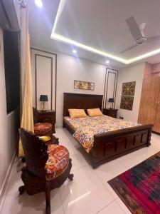 1 dormitorio con 1 cama y 1 silla en Luxuriant 3 Bed Apartment Defence Residency DHA Phase 2 Islamabad The Realtors Inn en Islamabad