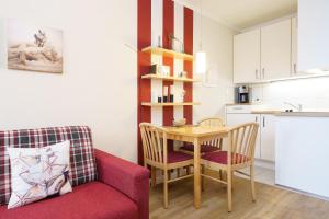 uma sala de estar com um sofá vermelho e uma mesa em Seepark Sellin FeWo AG 677 em Ostseebad Sellin