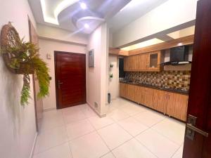 a large kitchen with a red door in a room at Luxuriant 3 Bed Apartment Defence Residency DHA Phase 2 Islamabad The Realtors Inn in Islamabad