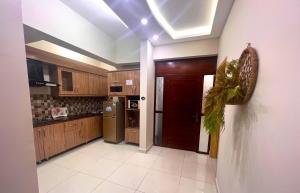 a kitchen with wooden cabinets and a red door at Luxuriant 3 Bed Apartment Defence Residency DHA Phase 2 Islamabad The Realtors Inn in Islamabad