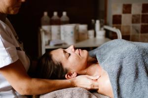 Eine Frau bekommt eine Massage von einem Therapeuten. in der Unterkunft Thermae Grimbergen Hotel in Grimbergen