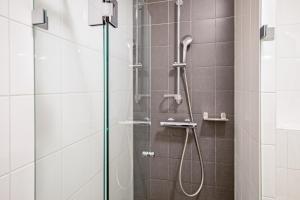 a shower with a glass door in a bathroom at Strandplevier Suites in De Koog +70 photos