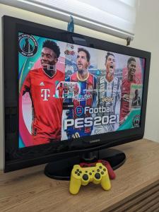 uma televisão com um controlador de jogos de vídeo numa mesa em Fatih Amani Guesthouse with Playstation PS3 em Kajang