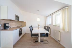 uma cozinha com mesa e cadeiras num quarto em Seepark Sellin FeWo AG Whg 705 em Ostseebad Sellin