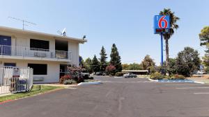 un estacionamiento sin señal de estacionamiento frente a un edificio en Motel 6-Chico, CA, en Chico