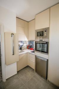 eine Küche mit Küchengeräten aus Edelstahl und einer Mikrowelle in der Unterkunft dreamy loft at 10th floor in Thessaloniki