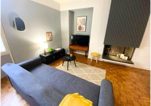 uma sala de estar com um sofá azul e uma lareira em Le 107 - Poitiers - CHU - La Conciergerie. em Poitiers