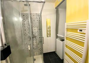 um chuveiro com uma porta de vidro na casa de banho em Le 107 - Poitiers - CHU - La Conciergerie. em Poitiers