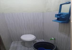 a small bathroom with a toilet and a bucket at HEINER HOMESTAY in Bunaken